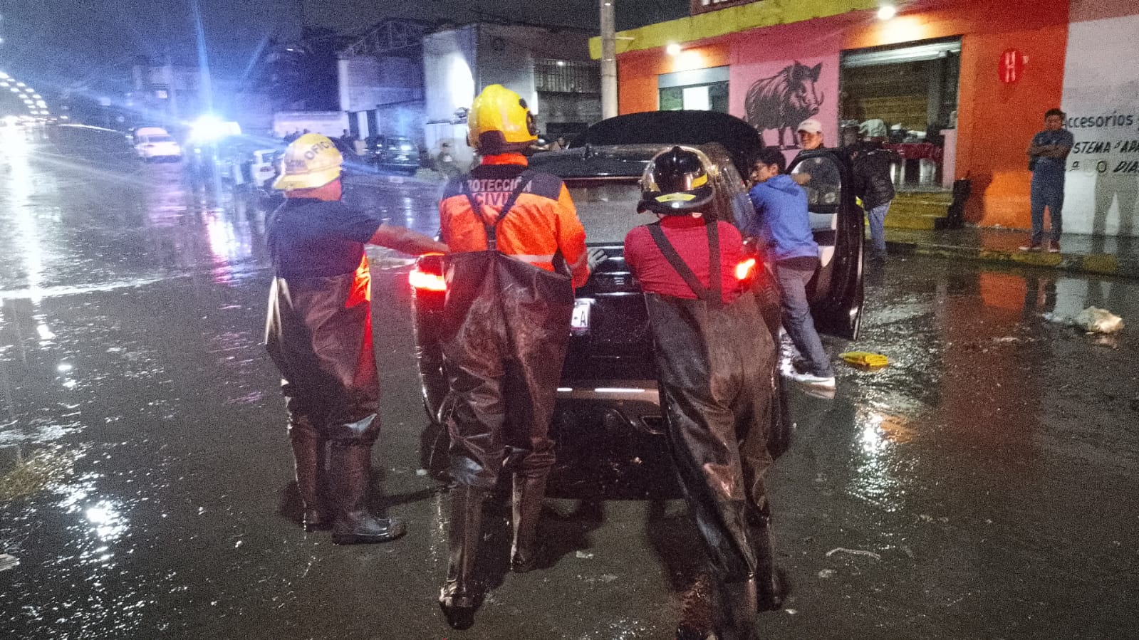 Protección Civil rescata a personas varadas por inundación en Tres Cerritos calle